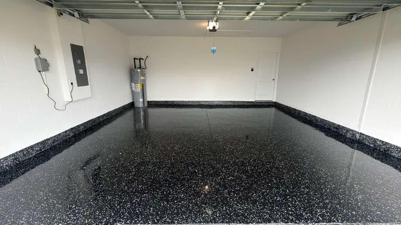 Black full flake epoxy garage floor with a glossy polyaspartic top coat installed by Epoxy One