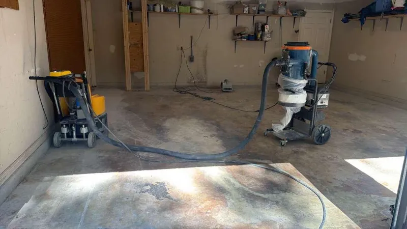 Diamond grinder and dust extractor preparing a garage floor