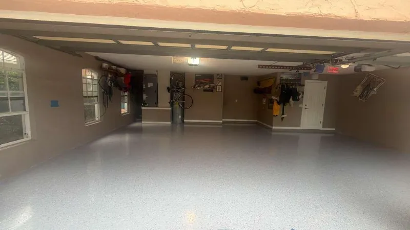 Gray epoxy garage floor with a partial flake application installed by Epoxy One